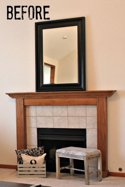 A tiled fireplace with a wooden mantel and a mirror above it.