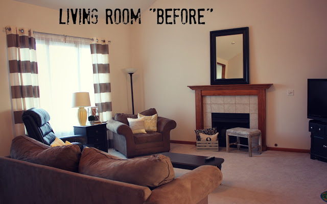 A carpeted living room with an old fireplace and old couch.