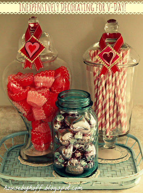 Candy in clear jars with love hearts on ribbons around the top of the jars.