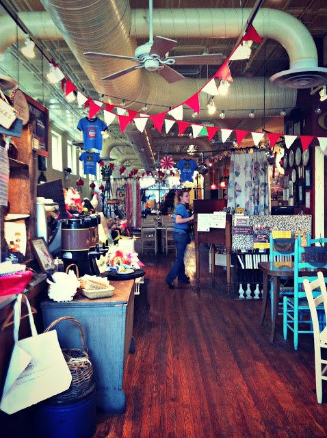 The inside of a restaurant with colourful banners and multi coloured chairs.