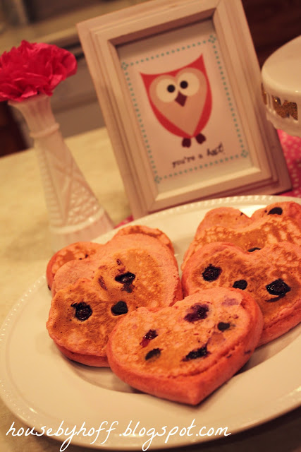 Heart shaped pancakes on a white plate on the table.