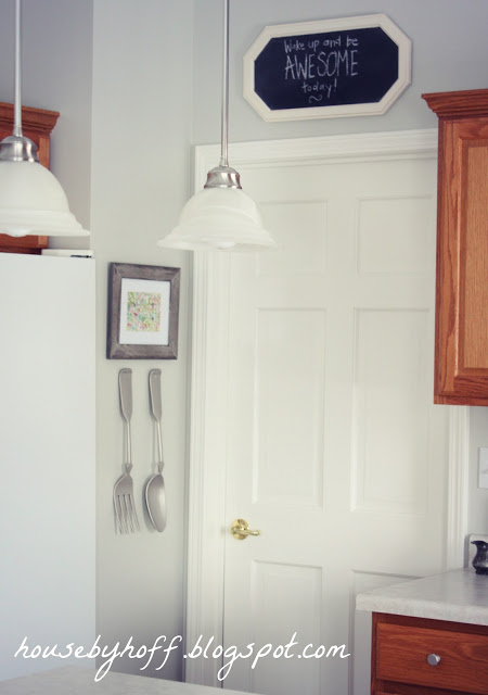 A view of the kitchen with the art hanging on the wall.