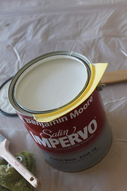 Can of white paint on a drop sheet.