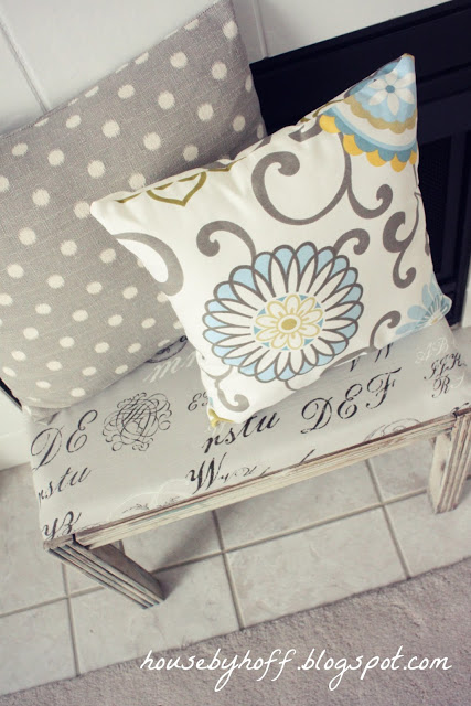 how to improve an outdated fireplace via housebyhoff.com A cute bench in front of the fireplace with throw pillows on it.