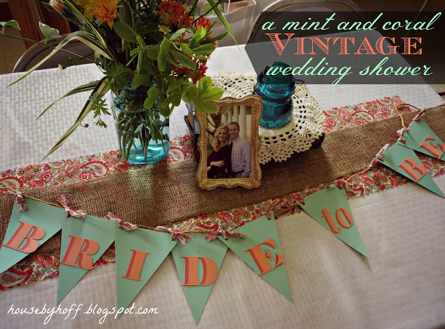 Table with bride to be banner on front in mint and coral.