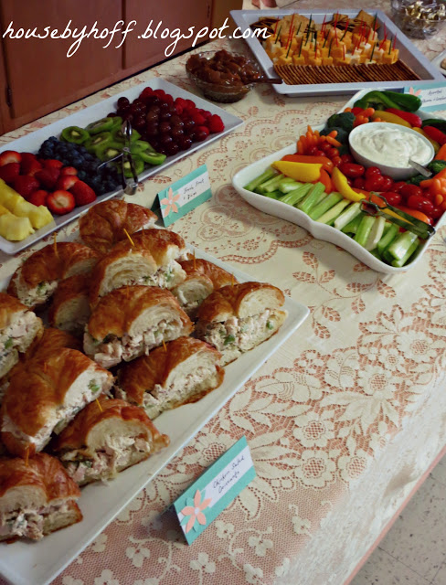 Table of food with sandwiches and fruit and vegetable tray.