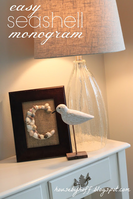 Seashell monogram in a frame on a desk.