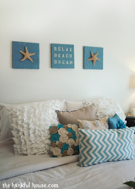 Bedroom with beachy pictures above the bed.