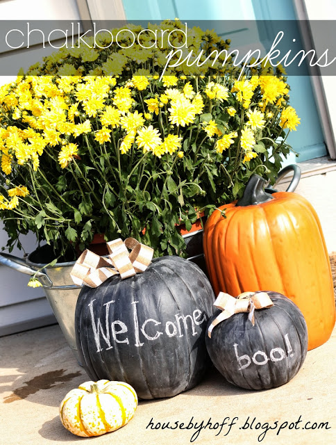 Fake pumpkins spray painted with welcome and boo on the front porch.