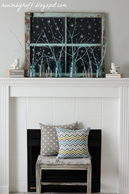 White fireplace mantel with bench in front and pillows on bench.