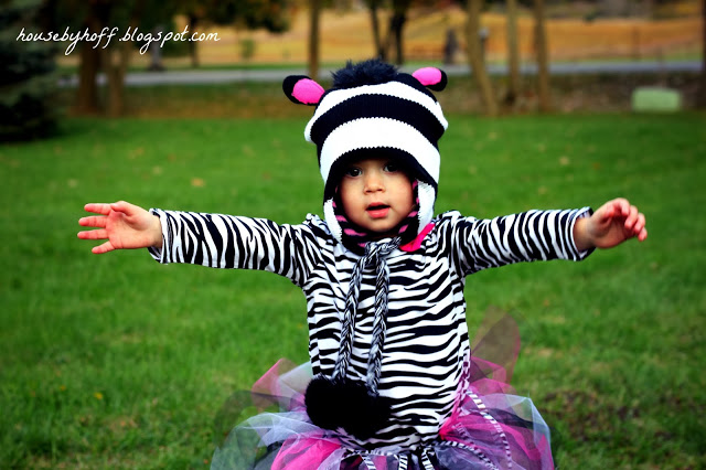 Zebra costume girl with arms out for a hug.