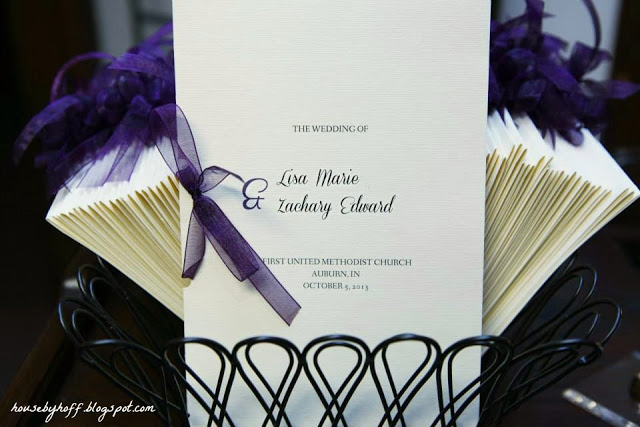 DIY wedding invitation with a purple ribbon in the white card.