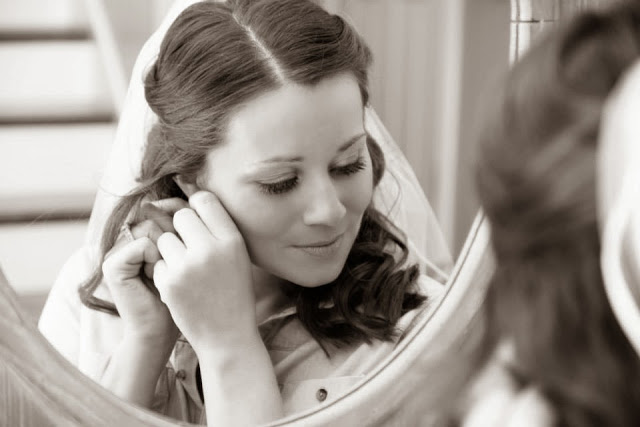 A bride putting in an earring.