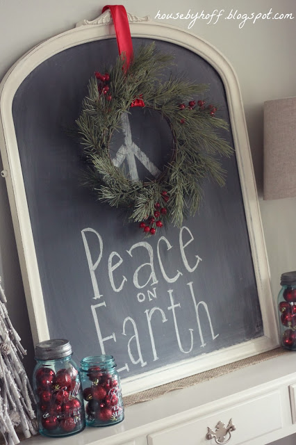 Peace on earth on the chalkboard with a small wreath hanging from a red ribbon.