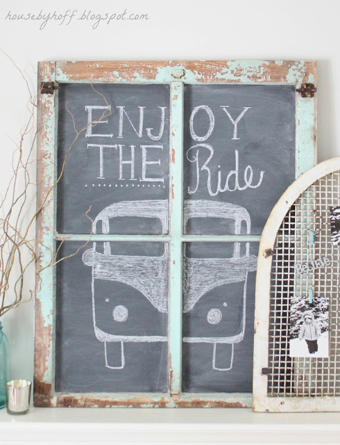 A chalkboard on the mantel with a drawn VW bus saying enjoy the ride.