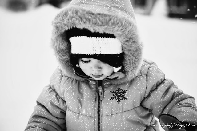 A little girl playing outside in the snow.