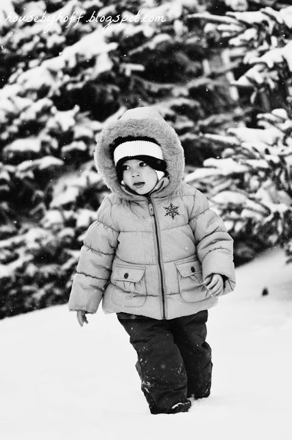A little girl walking through the snow.