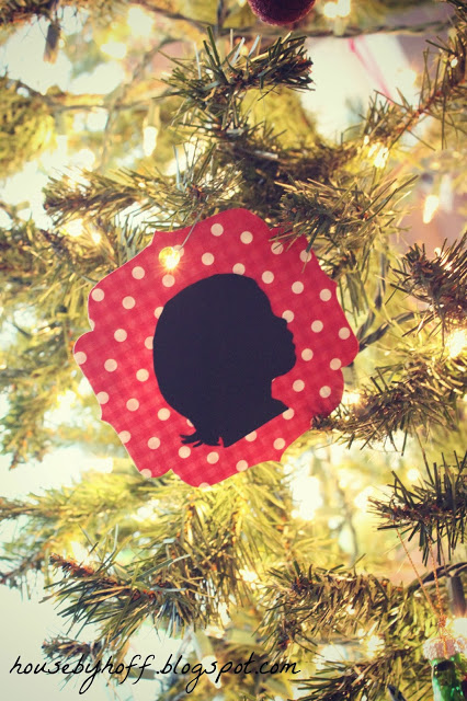 The silhouette on a red and white polka dot paper cut out and on the tree.
