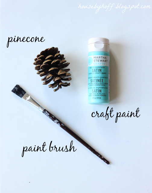 A paint brush, pine cone, and paint.