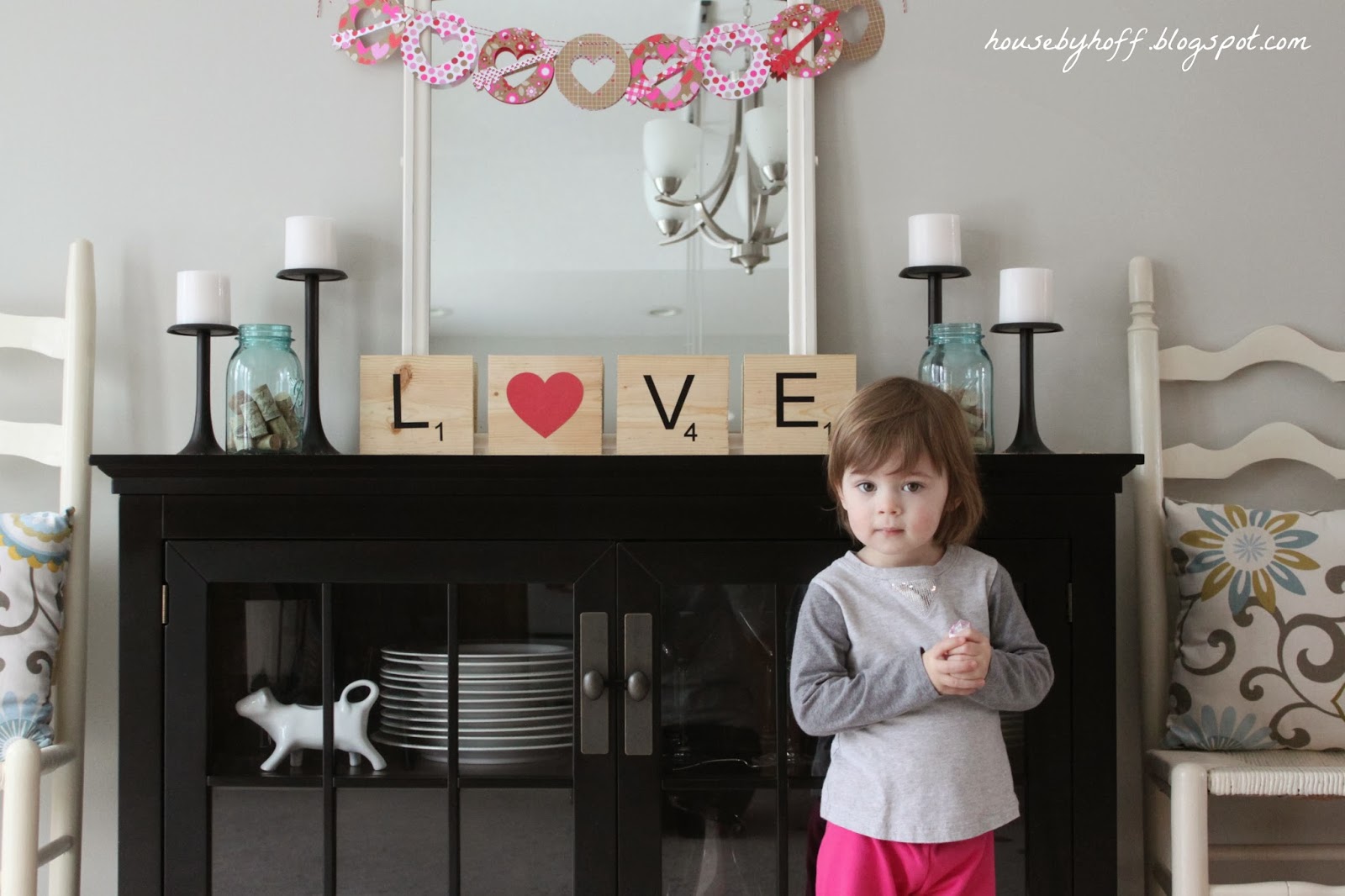 Little girl posing in front of the Love art.