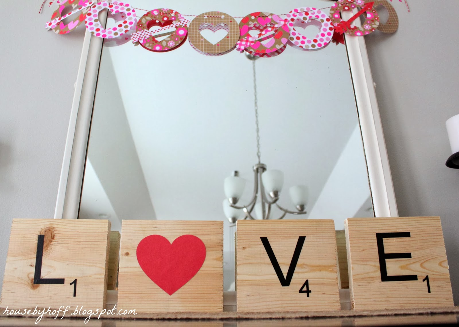 A scrabble love sign displayed in front f a mirror.