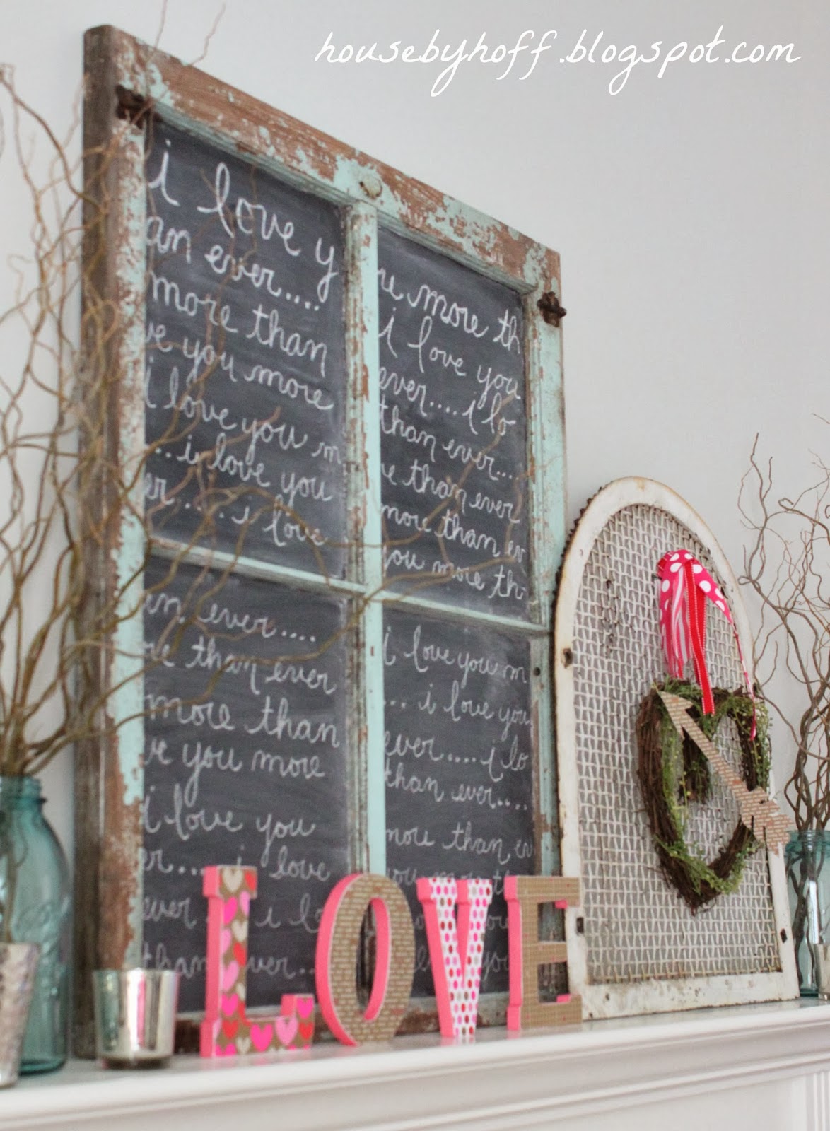 A love sign on the mantel beside the wreath.