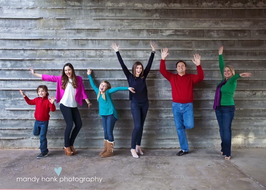 A family of six waving their arms in the air.