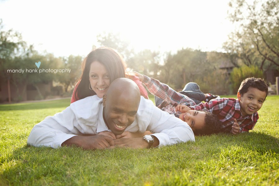 Family lying on their stomach on the grass.