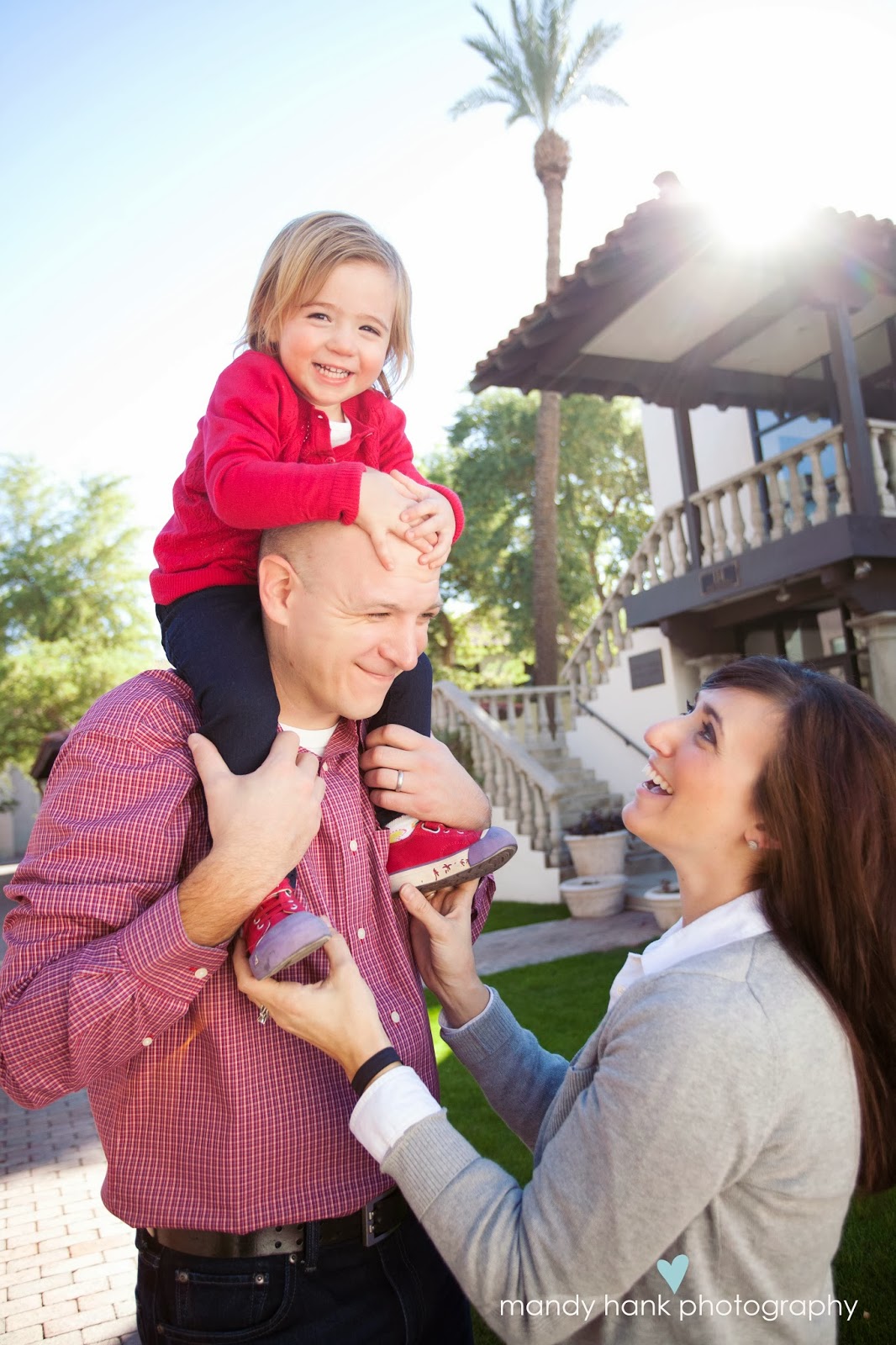 A parent holding a child on his shoulders.