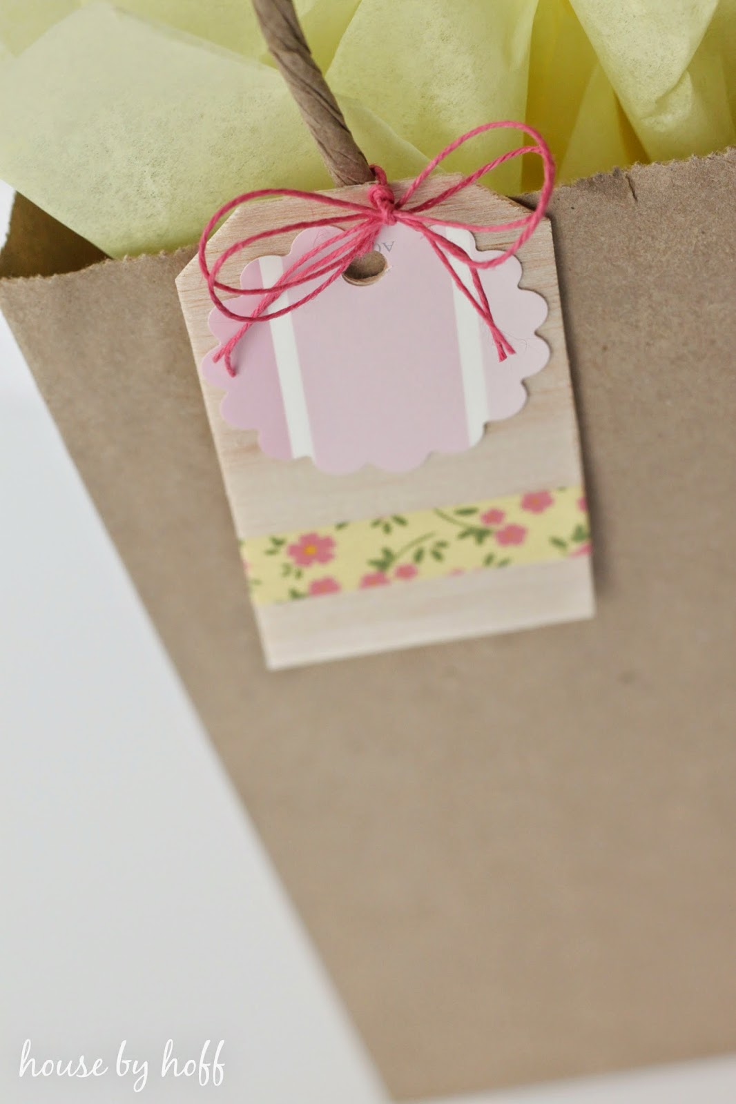 Balsa wood gift tag on a paper gift bag.