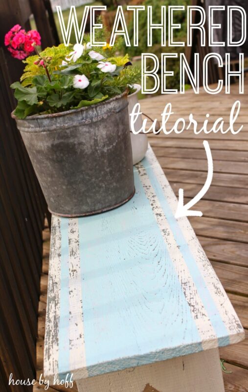 Weathered bench with pot of flowers on it.