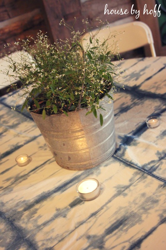 Greenery in a galvanized bucket on table.