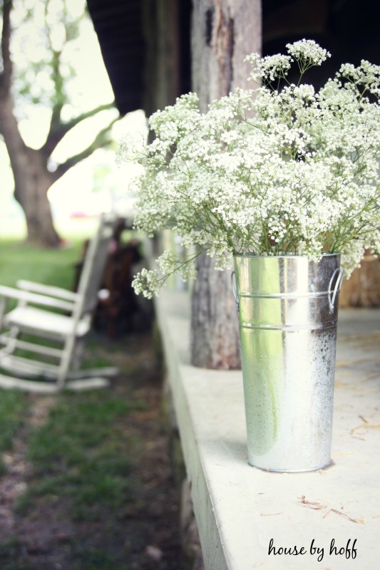 Galvanized steel containers with flowers in them on table.