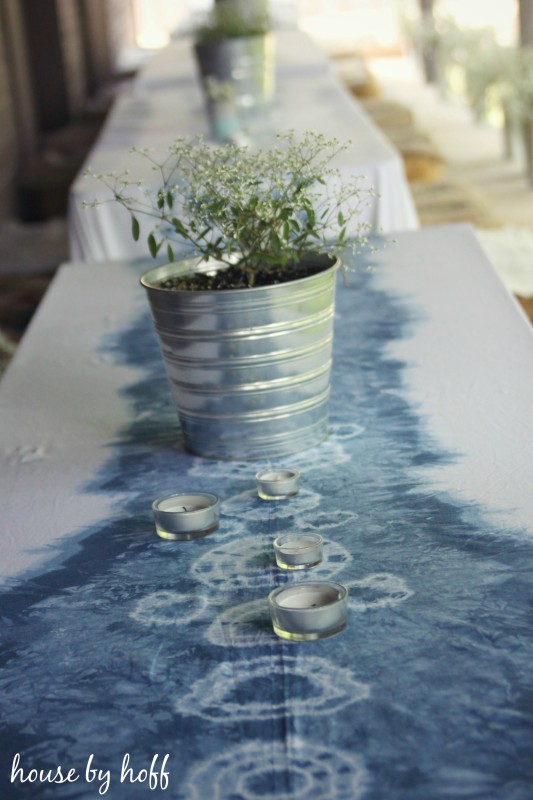 Tie dyed table cloth in soft blue and white with plant on table.