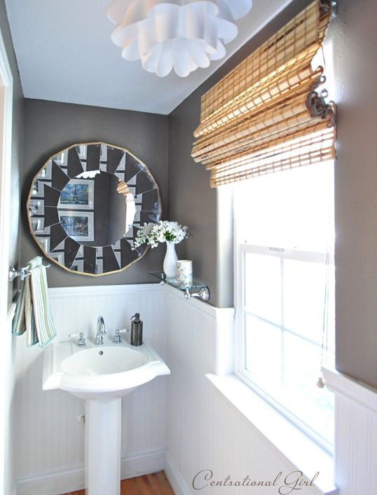 Ballard mirror on wall in bathroom and stand alone sink.