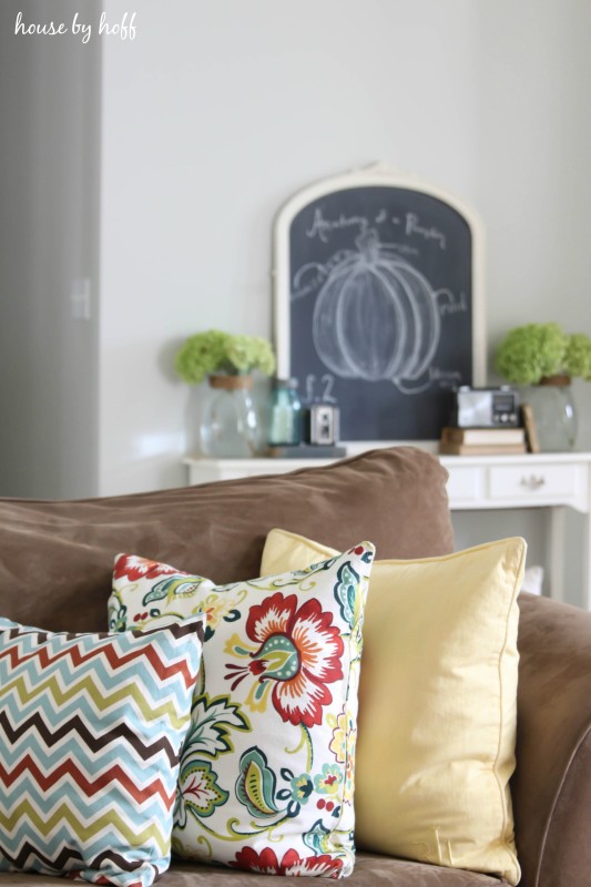 Couch with pillows and side table behind it.