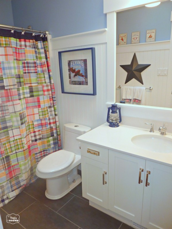 Plaid shower curtain and star picture in a blue and white bathroom.