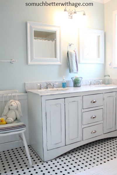 All white bathroom with checkered black and white floor.