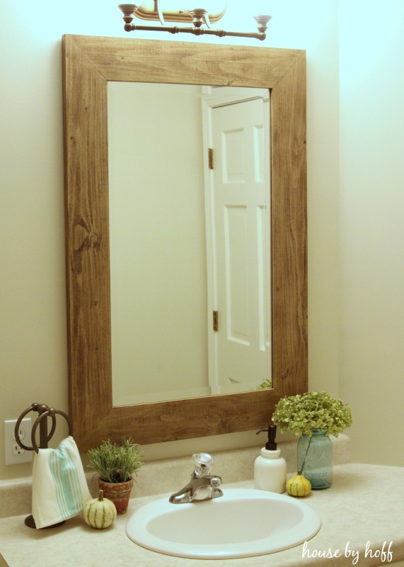 Beachy wooden mirror in bathroom.