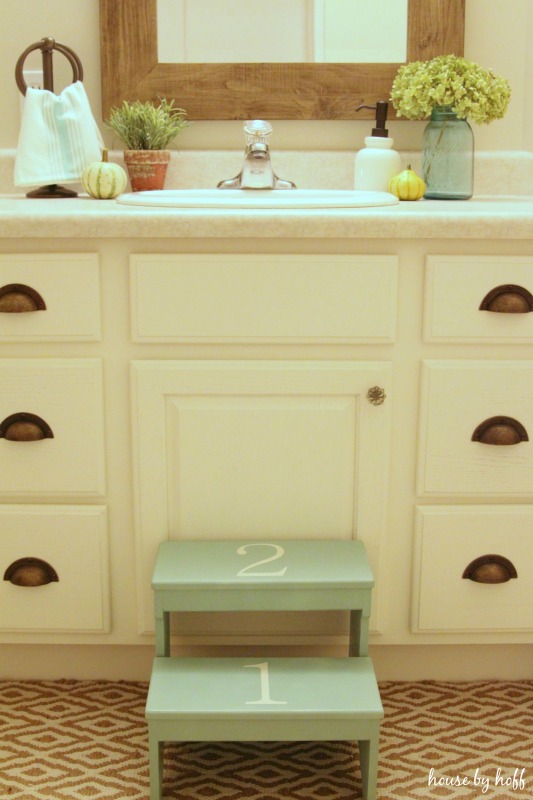 Brass hardware on white cabinets in bathroom makeover.