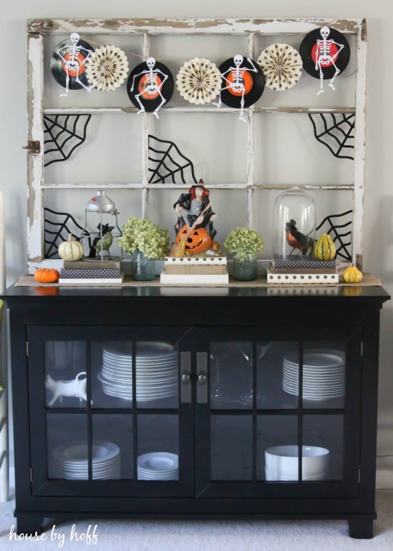 Living room hutch with old window frame decorated with a Halloween vignette.