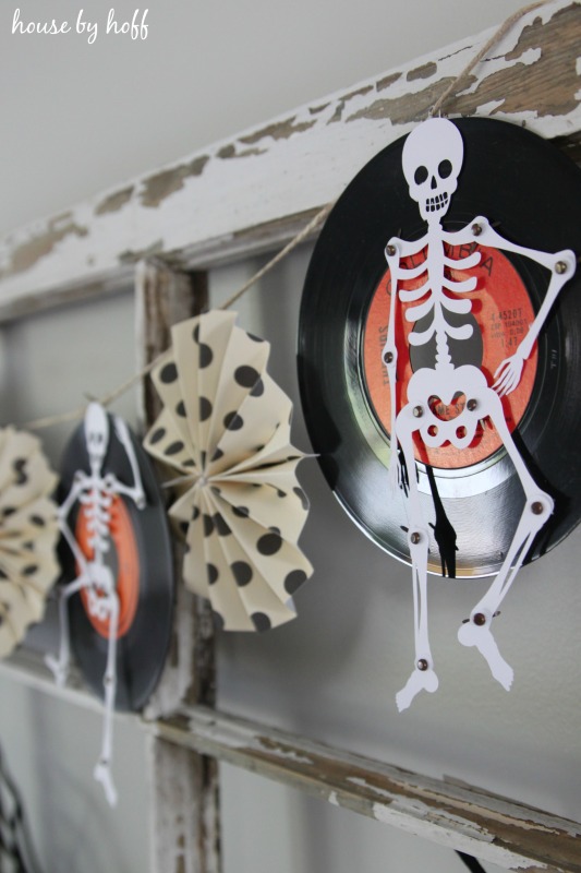 Vintage records with skeletons on them hanging on the window frame.