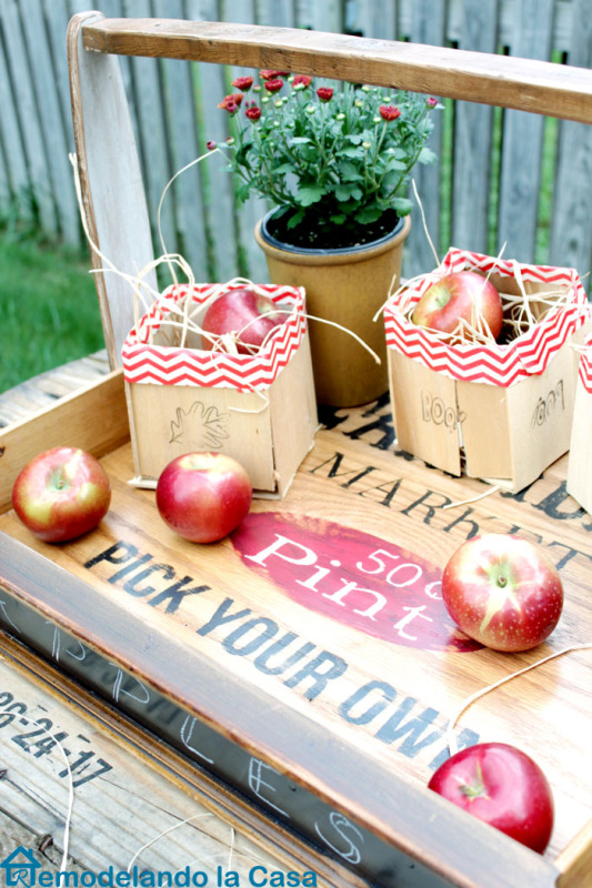 A wooden tray with apples on it.
