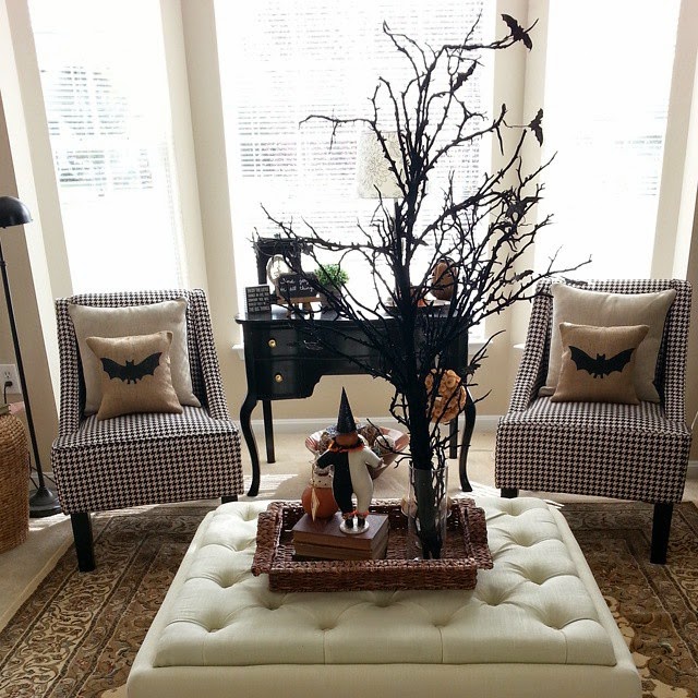 Bat pillows on chairs in the sitting room plus on the ottoman there is a fall centerpiece.