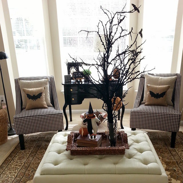 Living room with two accent chairs and white pillows with bats on them.