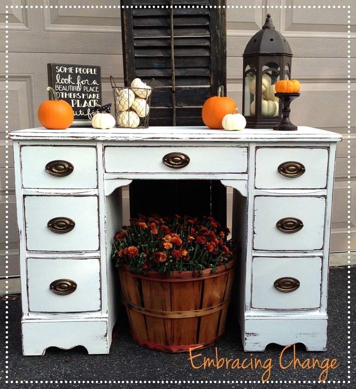 White distressed desk with orange pumpkins on it.