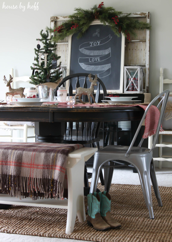 There are a pair of cowboy boots beside the dining room table.