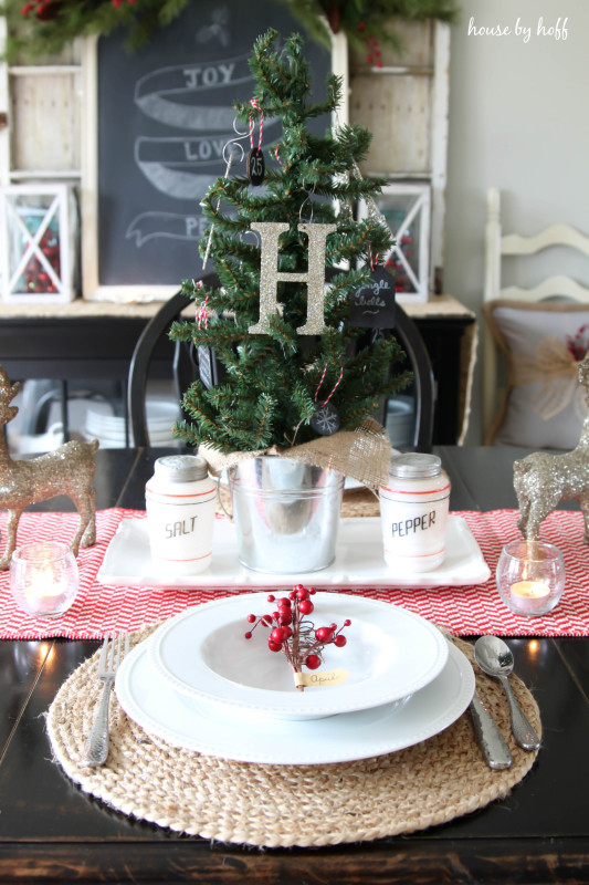 There is a mini Christmas tree as the centerpiece with the letter H hanging on it.