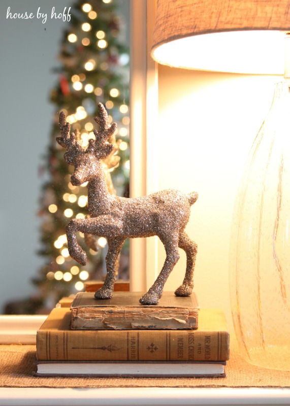 Up close of the sparkly deer figurine on top of old books.