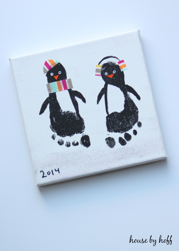 Two penguins with multicoloured hats and scarves on.